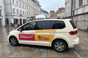 Ein Taxi der Taxi Regensburg eG mit FREENOW-Beschriftung in der Altstadt. Durch die Kooperation können Fahrgäste Fahrten in Regensburg einfach digital buchen. | Foto: Taxi Regensburg eG/FREENOW