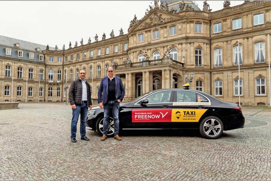 Iordanis „Danis“ Georgiadis (li.) und Alexander Mönch präsentieren die neue Taxi-Außenwerbung. Diese wird beide Bestellwege bewerben, die Telefonnummer der TAZ und die App von FREENOW. Bild: Freenow