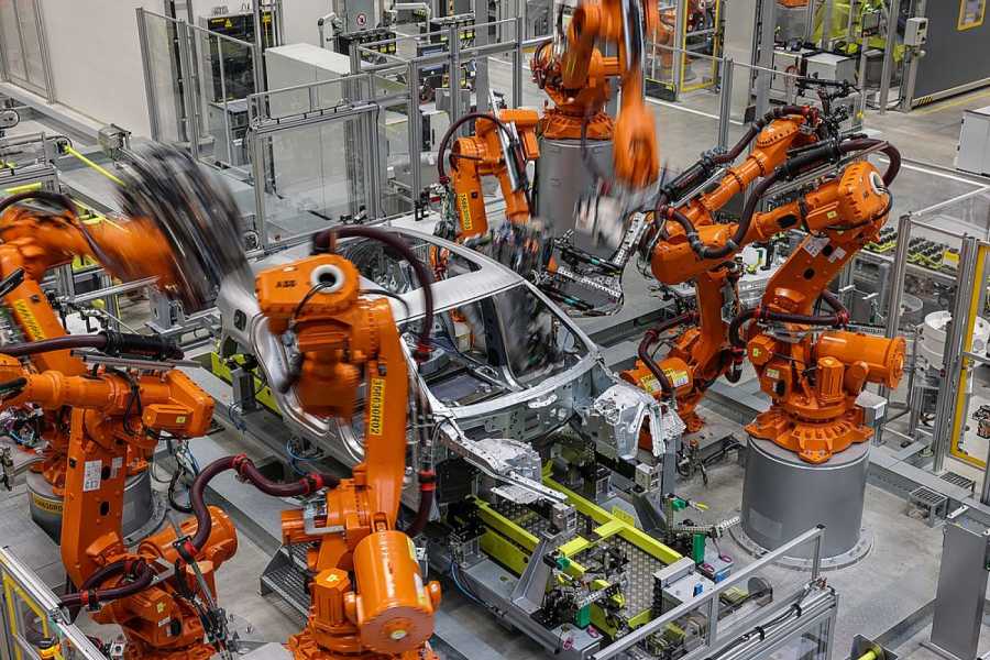 Industrieroboter arbeiten an der Karosserie für einen vollelektrischen Porsche Macan im Werk Leipzig. Laut einer Studie finden Kunden deutsche E-Autos attraktiver. (Foto: Jan Woitas/dpa)