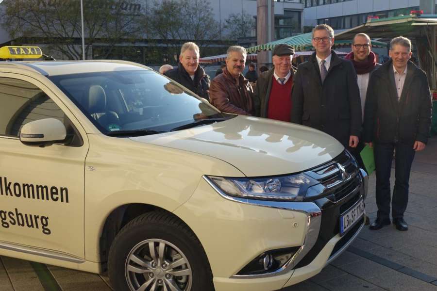 Frank Streicher (mit Mütze) bekam sein Taxi medienwirksam im Beisein des Ludwigsburger Bürgermeisters Michael Ilk (3.v.r.) überreicht. (Foto: Stadt Ludwigsburg)