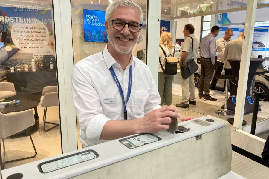 Krtitiker könnten einfach mal die Klappe halten: Die stabile Klappe des Ladebordsteins nämlich! Die solide Ausführung demonstrierte uns mit einem Augenzwinkern Ulrich Fischer, Leiter Marketing Civil Business. (Foto: G. Soller)