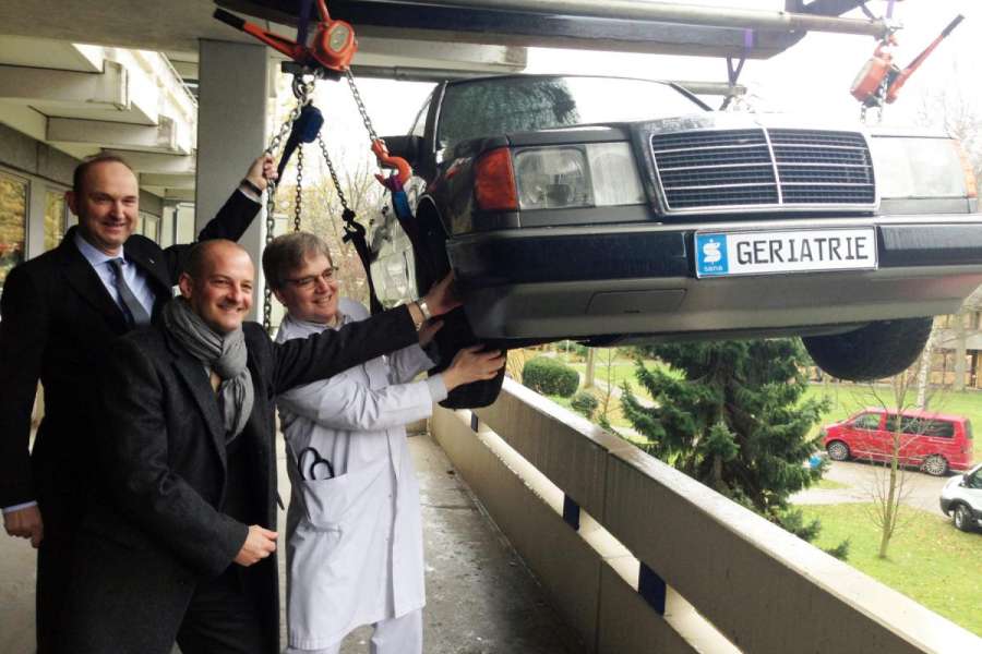 Am Kran empfangen Klinik-Geschäftsführer Dr. Stephan Puke (v.l.), Niederlassungsleiter Lars Reuter und Chefarzt Dr. Wolfrid Schröer den neuen „Trainings-Mercedes“. (Foto:Sana Kliniken Duisburg)
