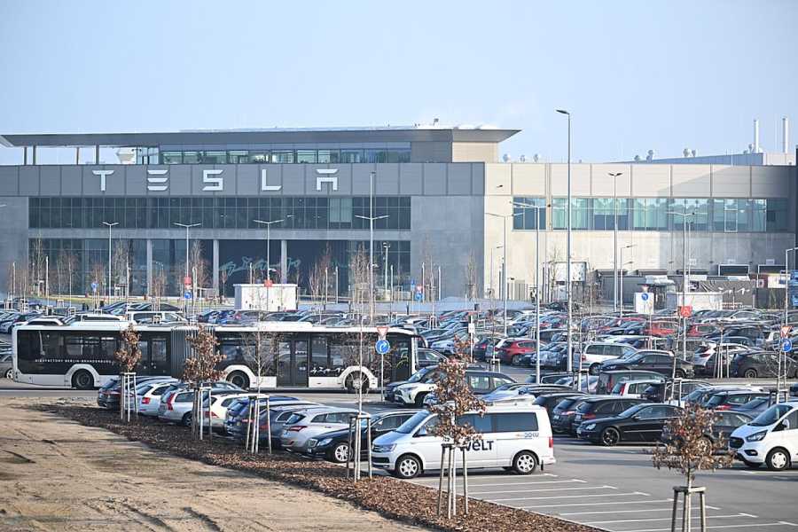 Die Morgensonne scheint auf den Eingang zum Tesla-Werk. Weniger sonnig sind allerdings die Aussichten von Tesla wenn es um den geplanten Ausbau der Fabrik geht. Der Ausbau scheint sich zu verschieben. (Foto: Sebastian Gollnow/dpa)