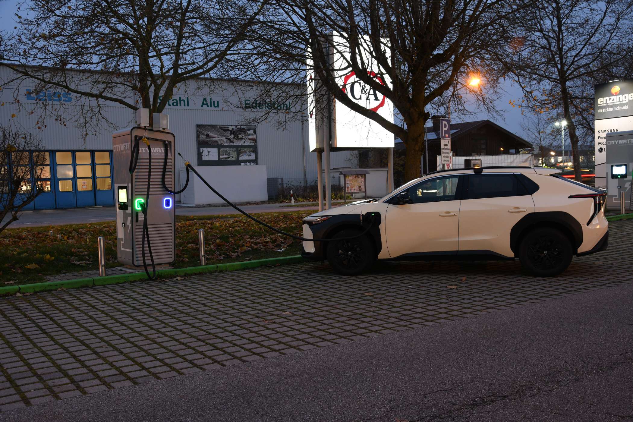 Am Vorabend einer langen Fahrt über Erlangen nach Thüringen zu einer Taxi-Versammlung wurde an einem Schnelllader bei Neuötting vollgeladen. Das Display zeigte dann eine Reichweite von 386 Kilometern an. Um die Ecke gibt es glücklicherweise einen Supermarkt mit einem Bäckerei-Café, in dem die Ladezeit im Warmen verbracht werden konnte.