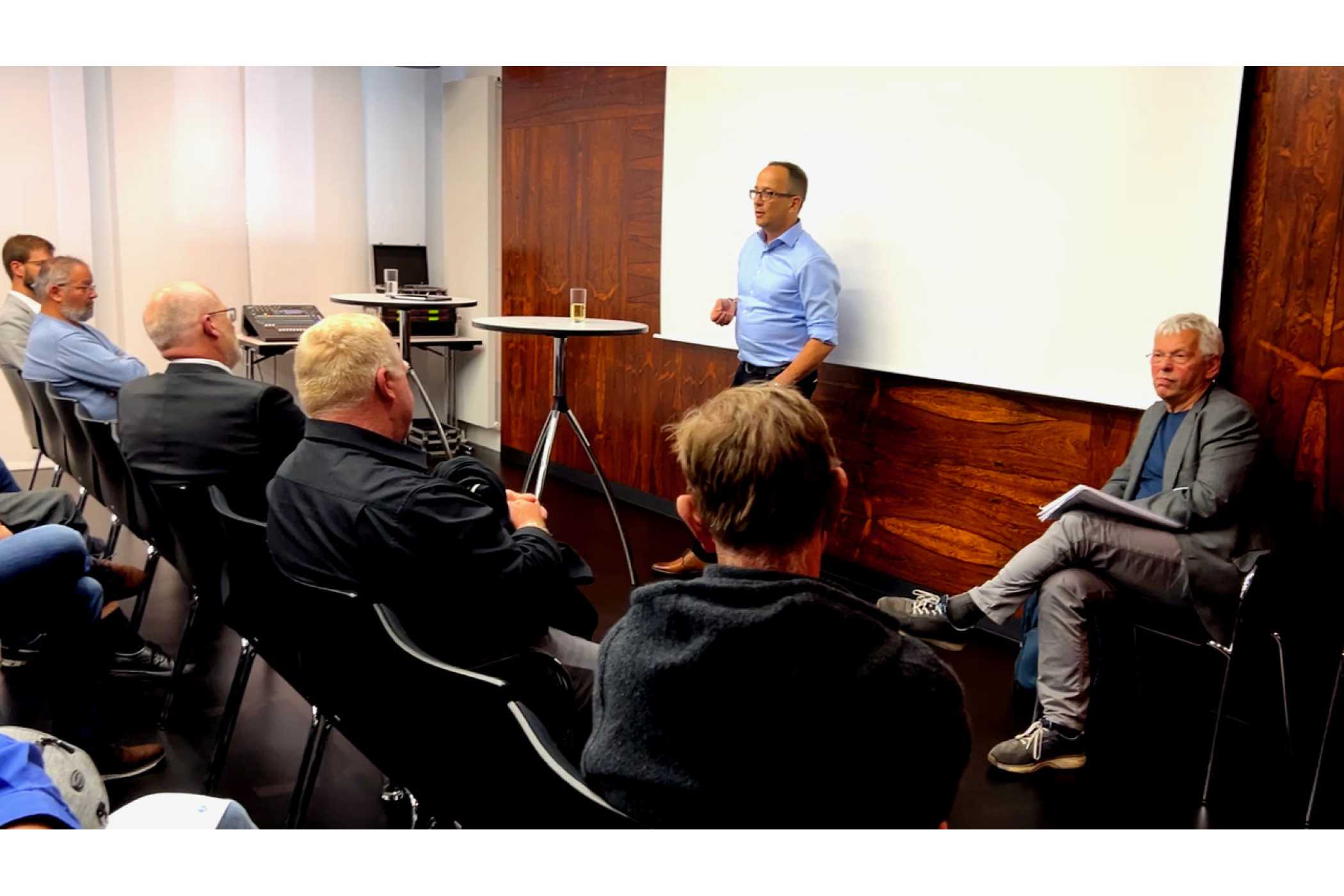 Jan Grupe, Vorsitzender der Taxenunion Hamburg (stehend) leitete den Workshop über E-Taxis. Der Mehrwagenunternehmer Rüdiger Lille (vorne rechts sitzend) brachte seine Praxis-Erfahrungen mit ein. (Foto: BVTM)