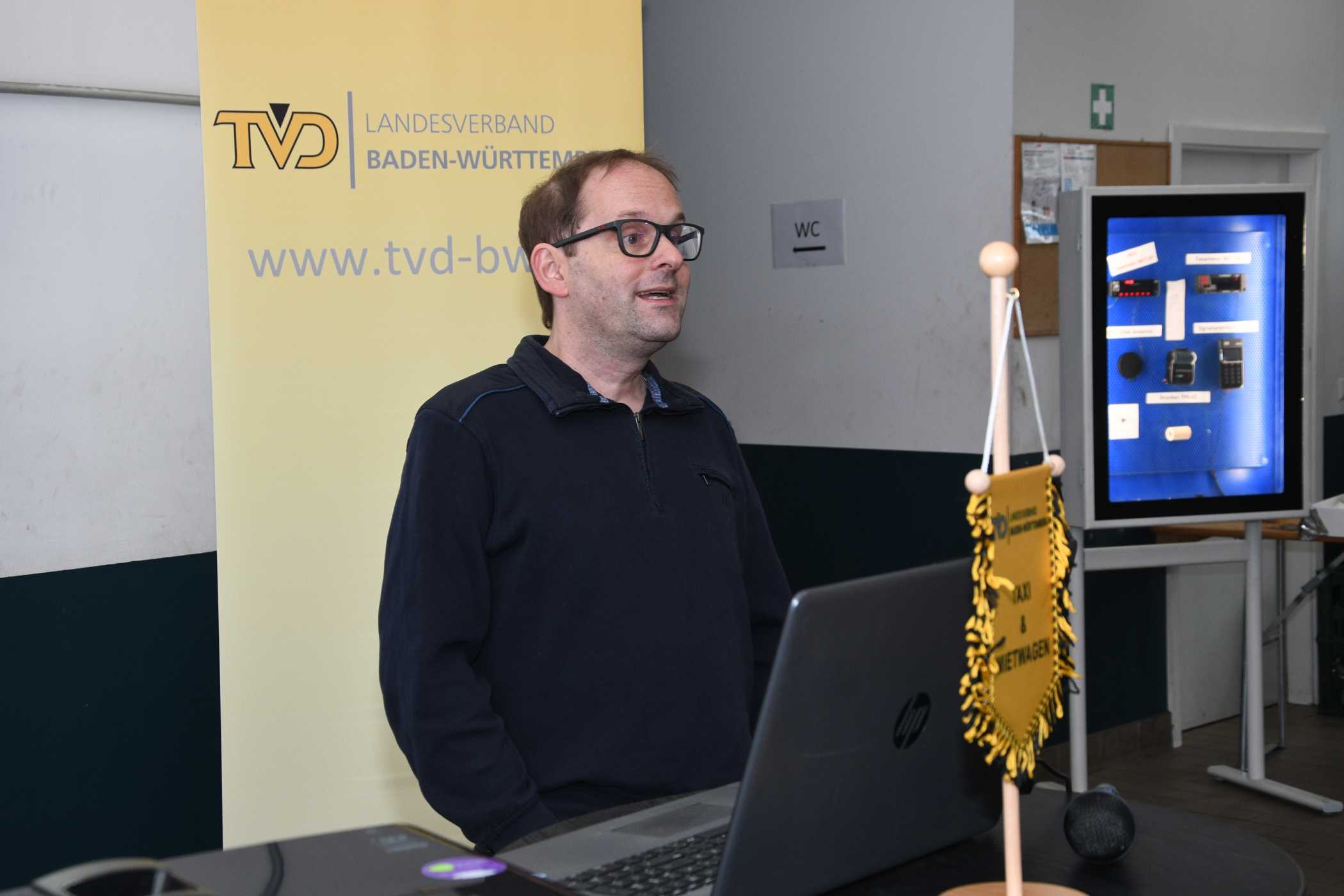 Mark Fischer ging in seinem Vortrag zunächst auf die TSE-Pflicht und die hierfür bestehenden Nachrüstmöglichkeiten ein. Er schilderte in den Pausen auch anhand einer Vitrine mit HALE-Geräten, wie die Nachrüstung praktisch aussieht.