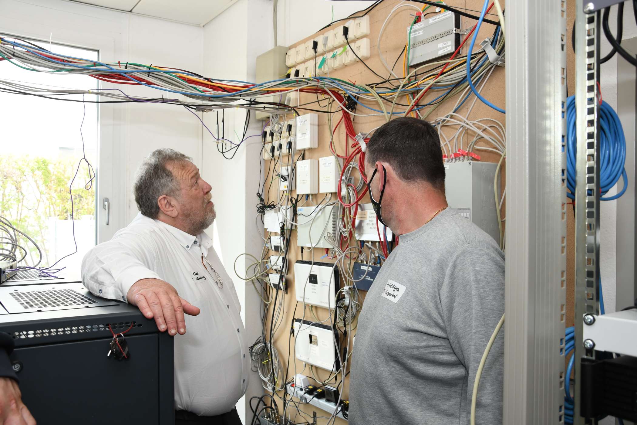 Reinhold Gast zeigte den Gästen wie Nico Höttges aus Wuppertal (r.) auch den Serverraum und informierte über ein Notstromaggregat, das einsatzbereit im Keller der Zentrale steht.