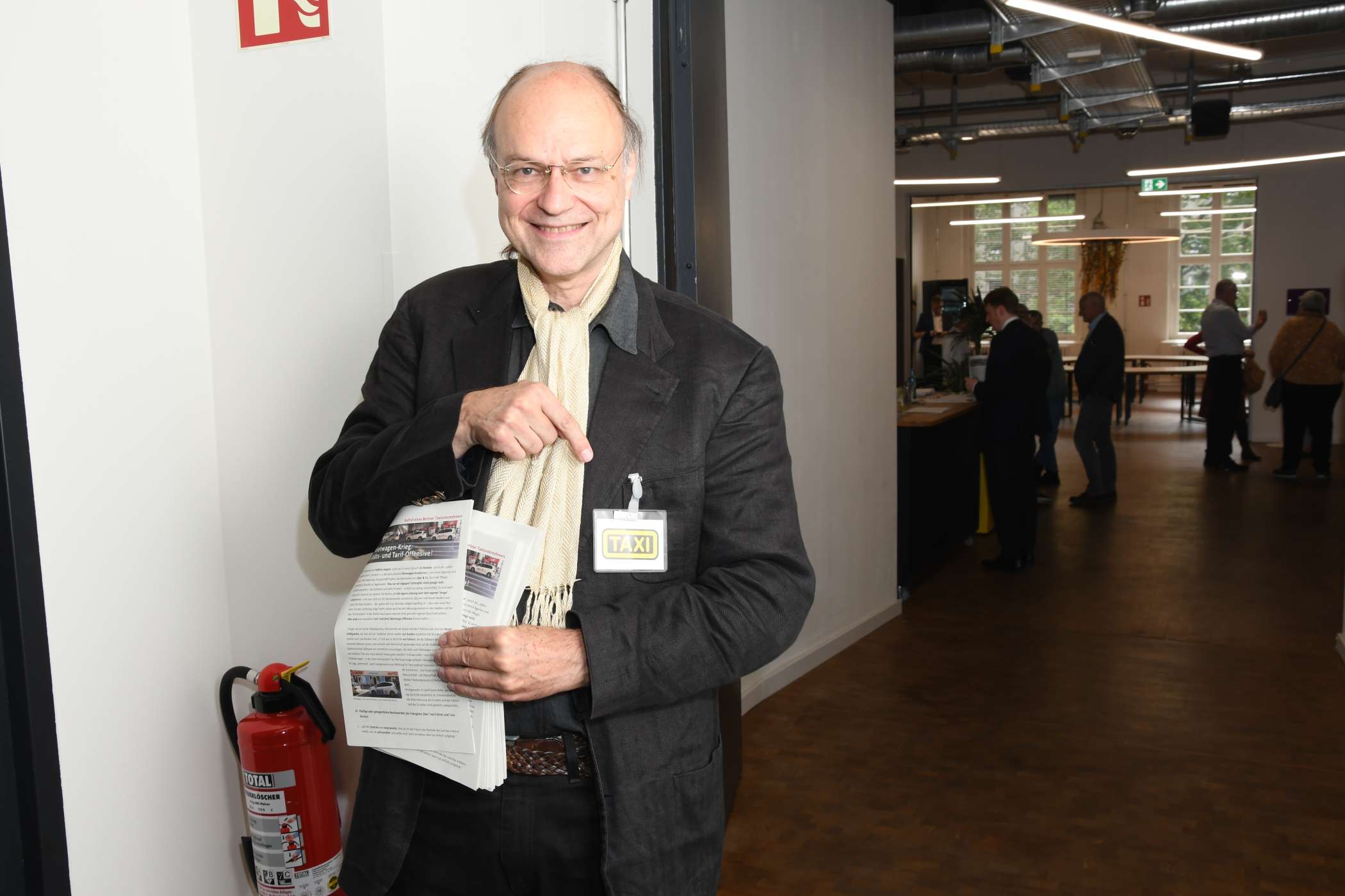 Der Berliner Taxiunternehmer Hilmar H. Werner verteilte am Eingang einen Text, mit dem er unter anderem für professionell mit Namensschild gekennzeichnete und in Taxi-Farben gekleidete Fahrerinnen und Fahrer warb.