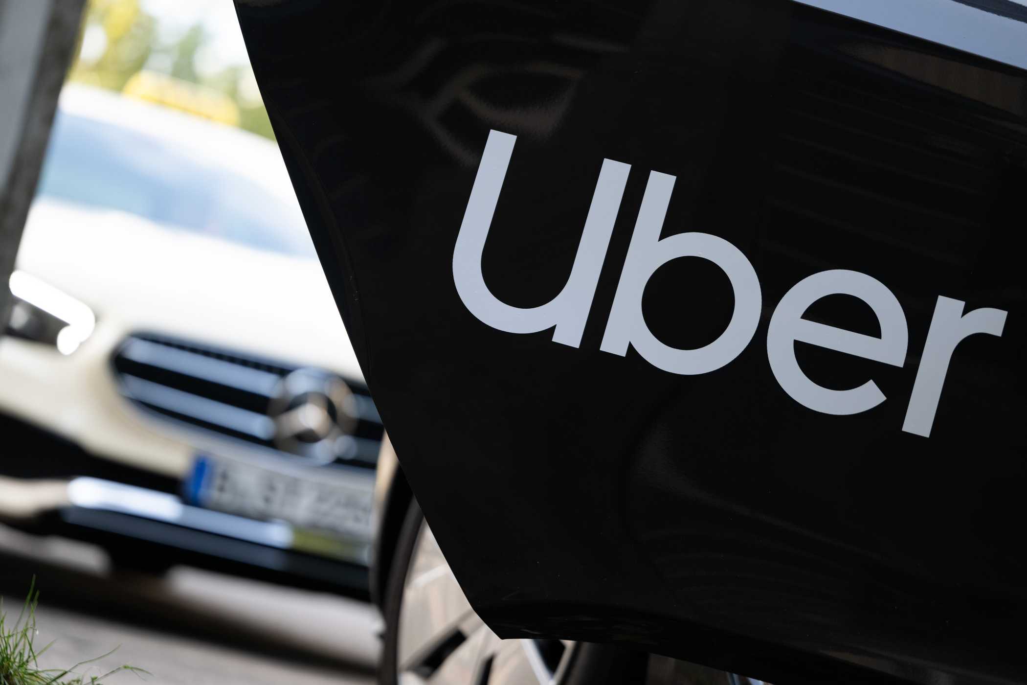 Platz 1: Uber und Bolt gegen Mindestpreise: Jetzt entscheidet die nächste Instanz » https://www.taxi-heute.de/node/31942 | Ein Mietwagen mit einem Schriftzug des Mobilitätsdienstleisters und Fahrtenvermittlers Uber steht vor einem Taxi, das auch über das Unternehmen gebucht werden kann. | Foto: Sebastian Gollnow/dpa