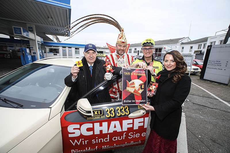Mit einem Foto von Taxifahrer Heinz Hirsch (l.) und dem diesjährigen Prinzenpaar macht Gesundheitsdezernent Prof. Andreas Meyer-Falcke auf die Aids-Gefahr aufmerksam. (Foto: Melanie Zanin/Stadt Düsseldorf)