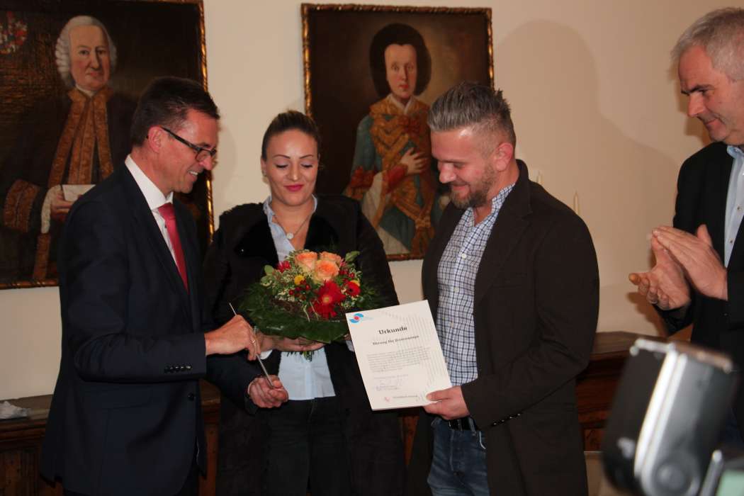 Der Erste Bürgermeister Joachim Bläse (l.) ehrte Bujar Hajdari, den seine Frau begleitete. (Foto: Stadtverwaltung Schwäbisch Gmünd)