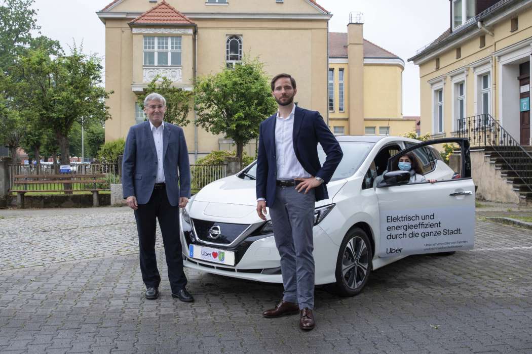 Wie zuvor in Kirchheim bei München stellt Uber Elektrofahrzeuge optisch in den Mittelpunkt. Mit einem solchen posieren hier Bürgermeister Heiko Müller (l.) und Uber-Deutschland-Chef Christoph Weigler. (Foto: Uber)