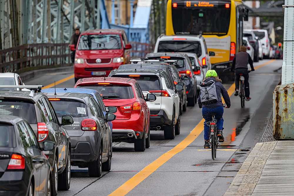 Radfahrer fahren an der Elbbrücke Blaues Wunder auf einem markierten Radweg an Autos im Stau vorbei. Der Radfahrstreifen ist Teil eines Versuchs, mit dem die Stadt eine neue Aufteilung des Verkehrsraums erproben will. Die FDP fordert nun eine "Politik für das Auto". (Foto: Robert Michael/dpa)