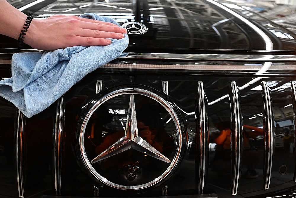 Mercedes- Benz fährt deutliche Rückgänge ein: Eine Mitarbeiterin des Stuttgarter Autoherstellers Mercedes-Benz arbeitet in der Factory 56 im Merecdes-Benz Werk in Sindelfingen in der Fertigung von Oberklasse- und Luxusfahrzeugen an einer Motorhaube an einem Mercedes-Emblem. (Foto: Bernd Weißbrod/dpa)