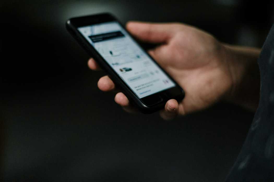 Ein Nutzer hält ein Smartphone mit geöffneter Fahrdienst-App in der Hand – das Landgericht Köln untersagte die Nutzung der Uber-App „Uber X“ in ihrer aktuellen Form wegen Verstoßes gegen das Personenbeförderungsgesetz. | Foto: Priscilla Du Preez via Unsplash